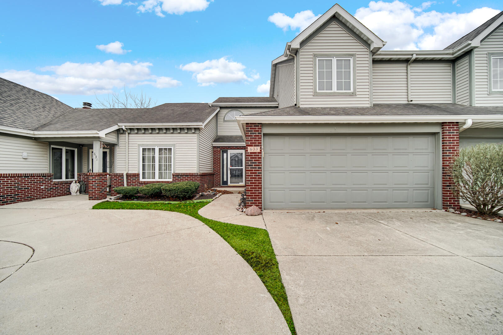 a front view of a house with a garden and garage