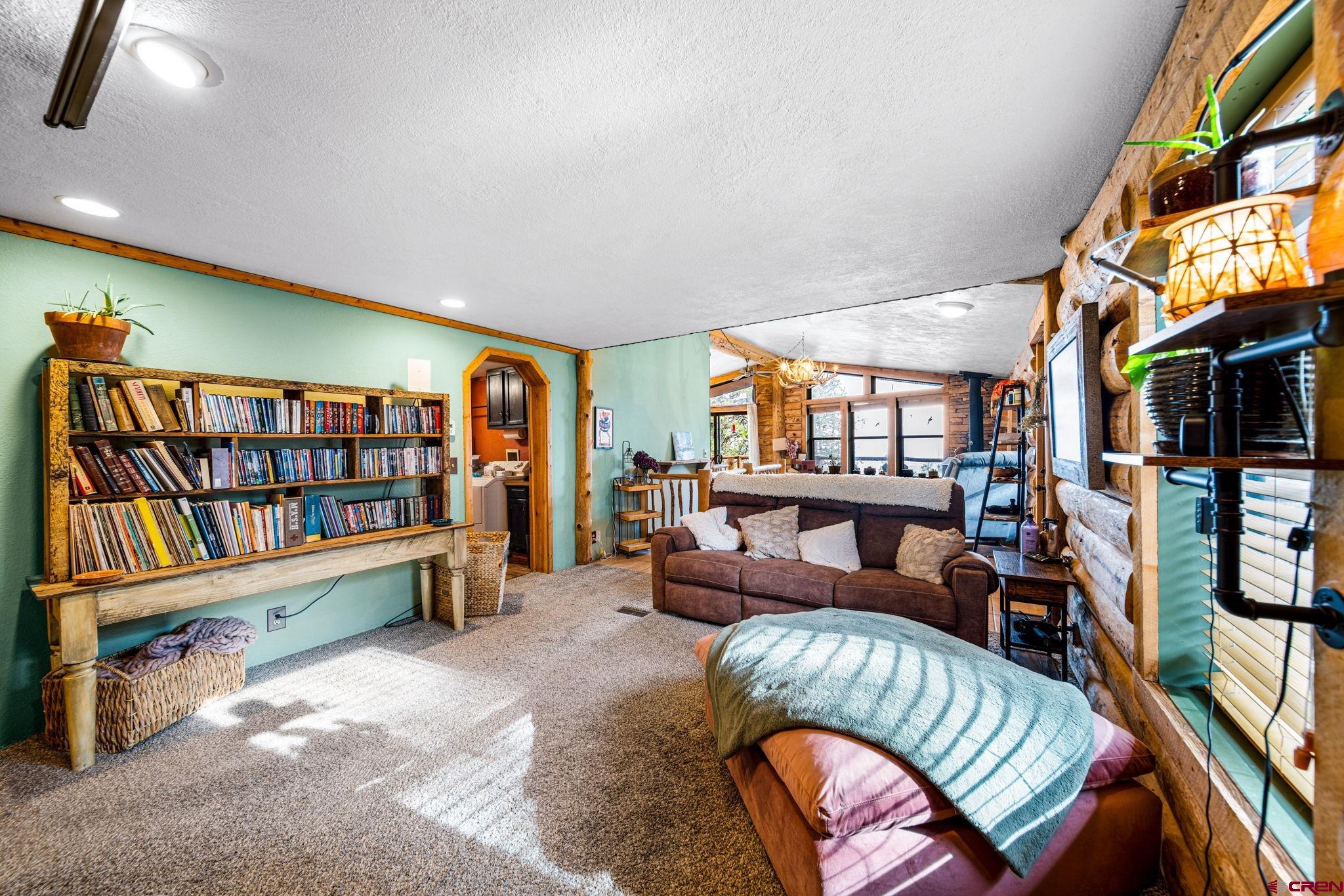 1118 Durango Road Durango, CO 81301 - Photo 21 of 32 a living room with furniture and a book shelf