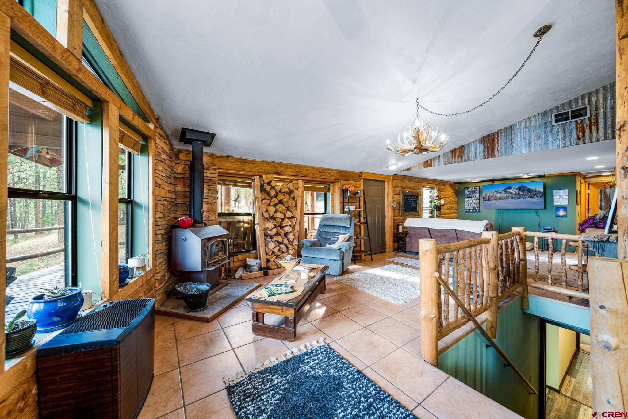 1118 Durango Road Durango, CO 81301 - Photo 22 of 32 a living room with furniture a fireplace and a large window