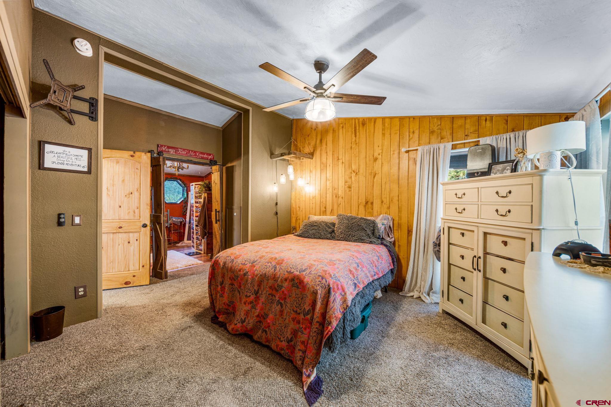 1118 Durango Road Durango, CO 81301 - Photo 23 of 32 a bedroom with a bed and a chandelier
