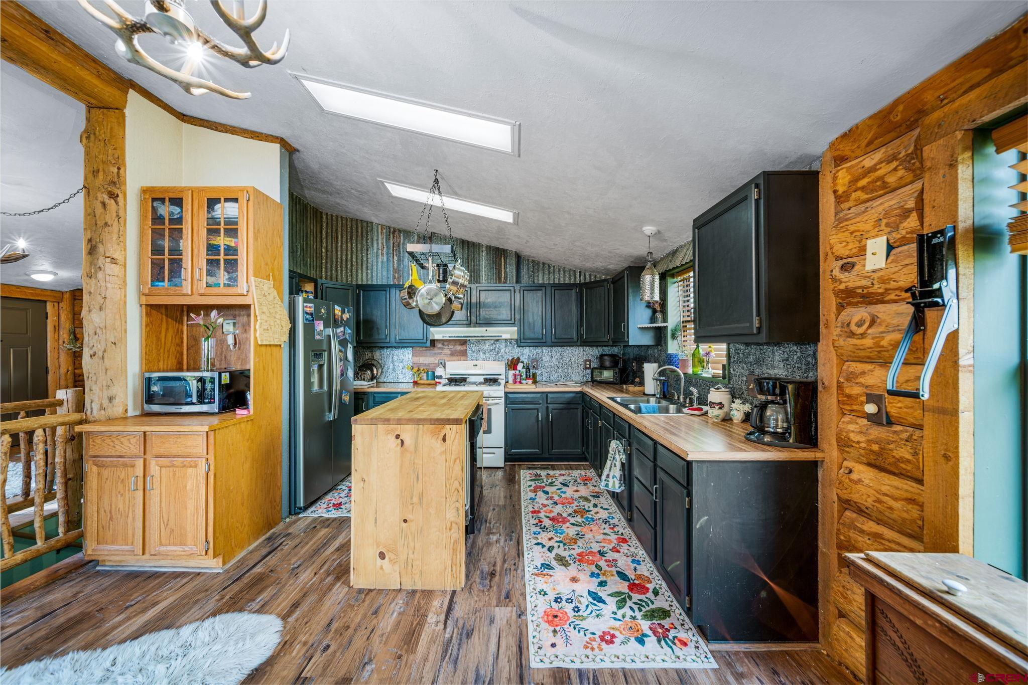 1118 Durango Road Durango, CO 81301 - Photo 7 of 32 a kitchen with stainless steel appliances kitchen island granite countertop a refrigerator a stove top oven and a sink with dishwasher
