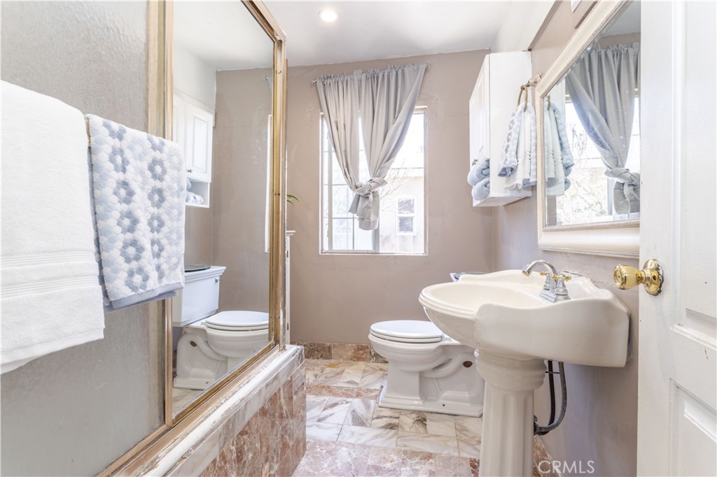 142 North Vendome Street Los Angeles, CA 90026 - Photo 17 of 33 a bathroom with a sink toilet a mirror and shower