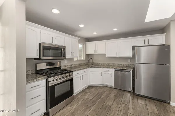 a kitchen with granite countertop appliances cabinets and a counter space