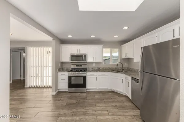 a kitchen with stainless steel appliances granite countertop a refrigerator sink and stove