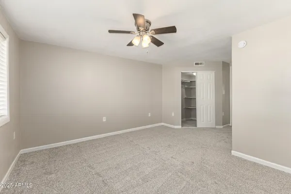 an empty room with closet and fan