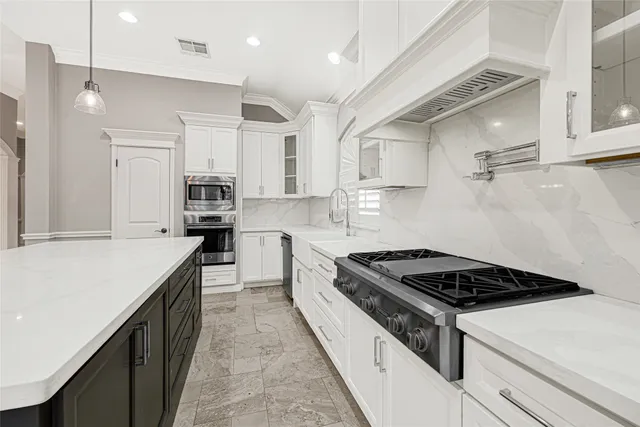 a kitchen with kitchen island a counter top space a sink stainless steel appliances and cabinets