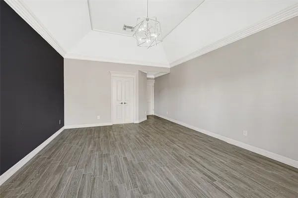 a view of a room with wooden floor and ceiling fan