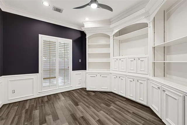 a kitchen with granite countertop white cabinets and white appliances with wooden floor