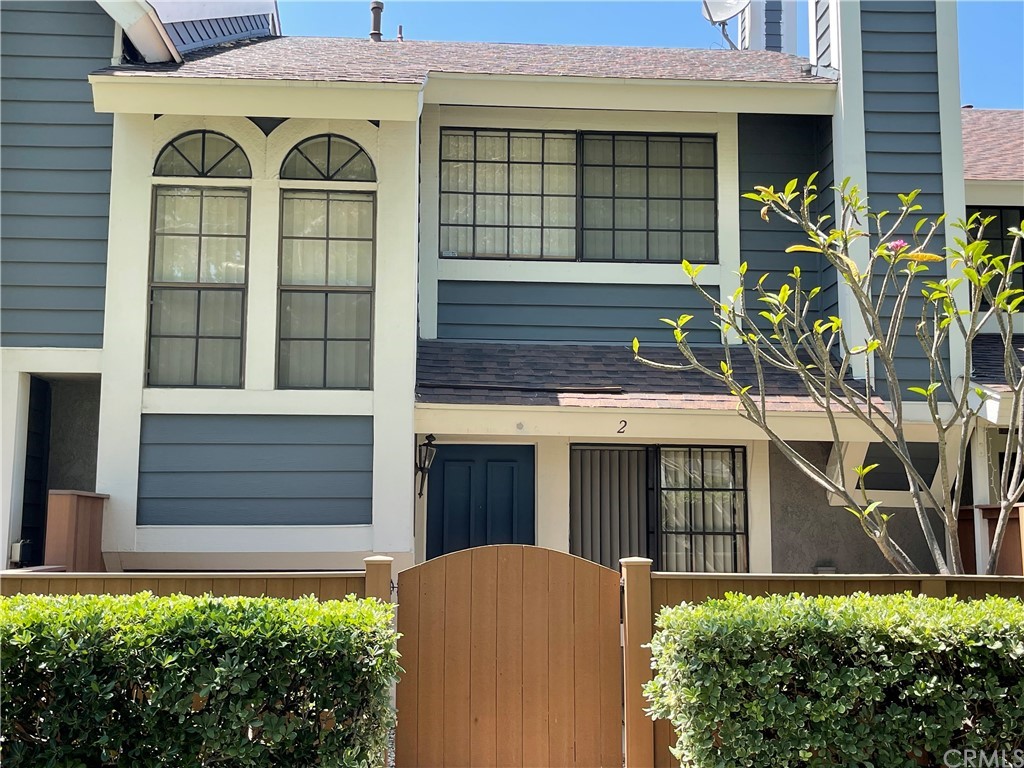a view of a white house with large windows and a small yard