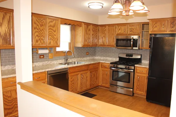 a kitchen with granite countertop white cabinets and stainless steel appliances