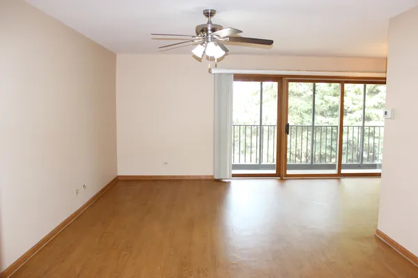 an empty room with a window and a ceiling fan