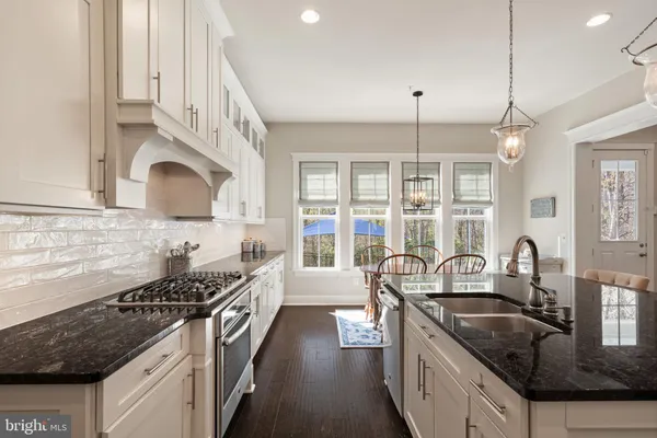 a kitchen with a stove a table and chairs in it