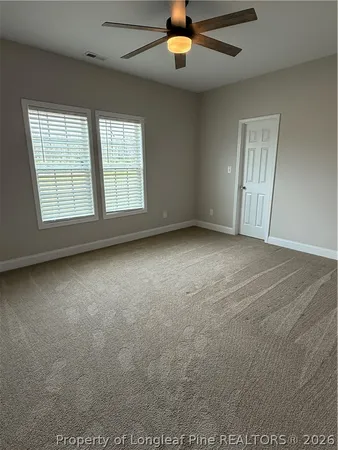 en empty room with windows and ceiling fan