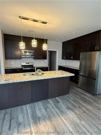 a large kitchen with kitchen island a large counter top a sink a stove and refrigerator