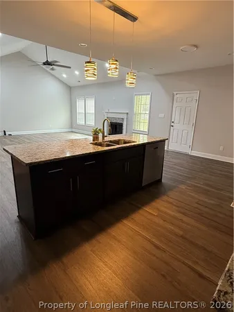 a kitchen with stainless steel appliances granite countertop a sink counter space and wooden floor