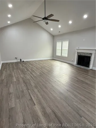 an empty room with wooden floor and a ceiling fan