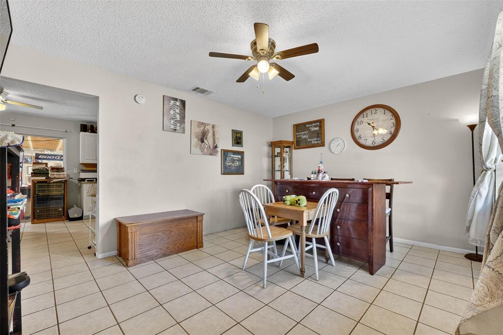 2613 Fowler Avenue Auburndale, FL 33823 - Photo 11 of 61 a dining room with furniture and a clock on the wall