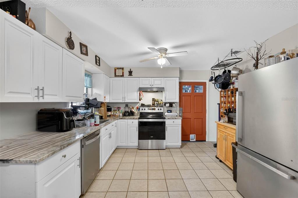 2613 Fowler Avenue Auburndale, FL 33823 - Photo 16 of 61 a kitchen with stainless steel appliances granite countertop a refrigerator a stove and a sink