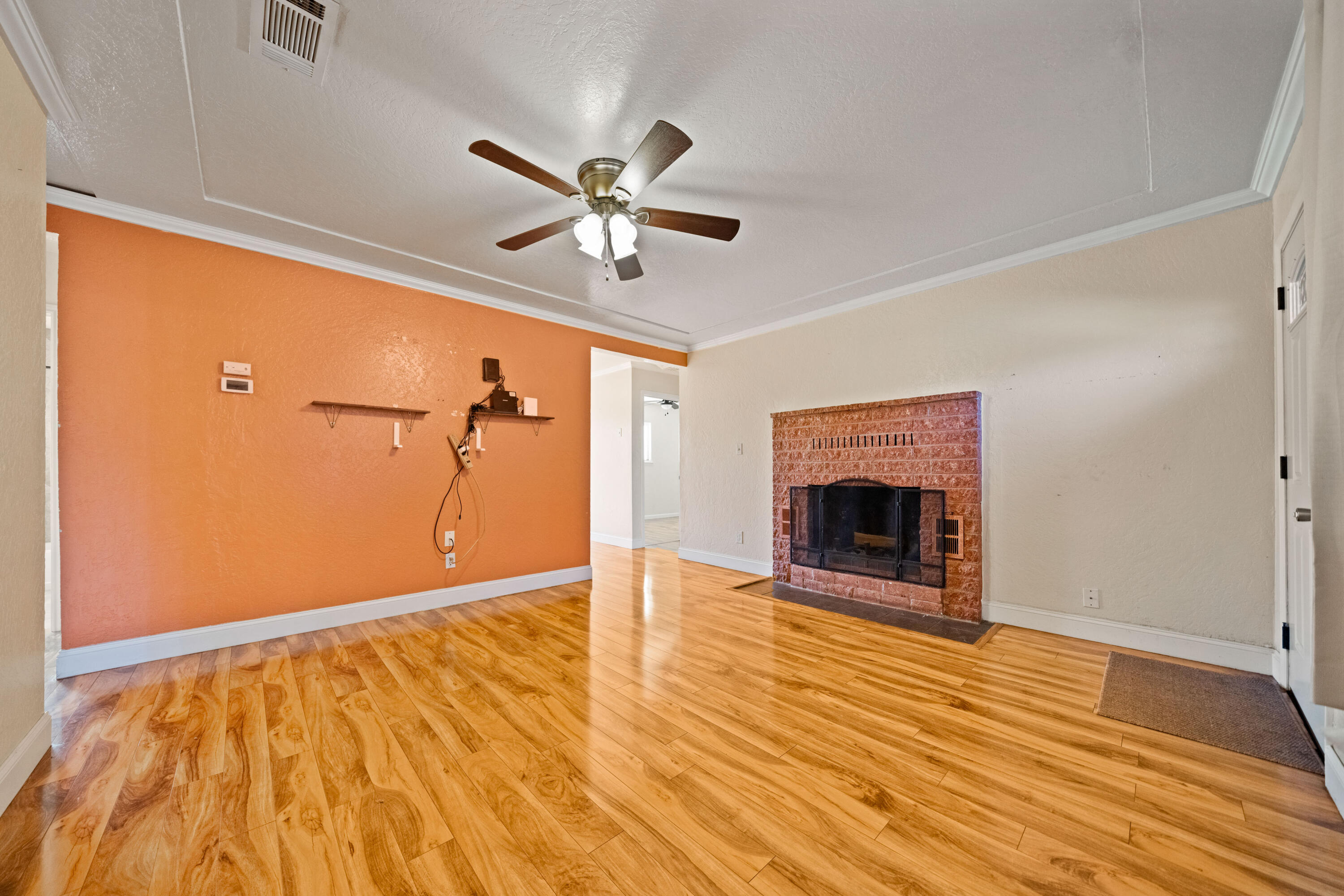 12161 Randolph Road Redding, CA 96003 - Photo 9 of 37 wooden floor in an empty room with a fireplace and a window
