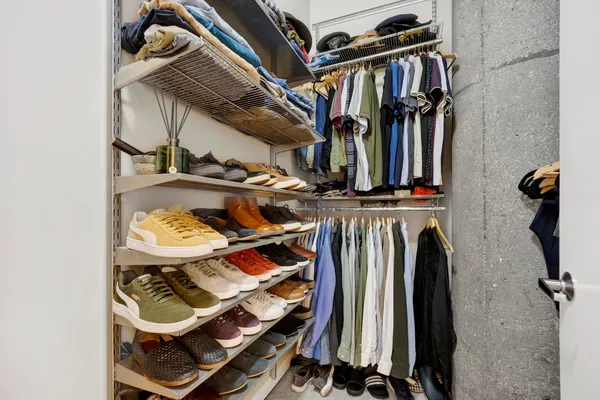 a view of walk in closet with clothes and shoes