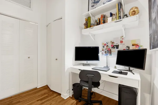 a view of a workspace with furniture and a window