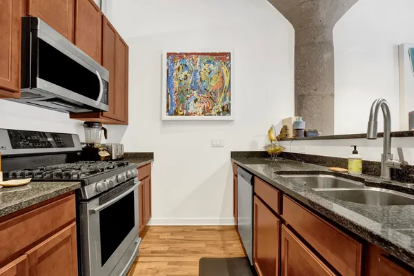 a kitchen with stainless steel appliances granite countertop a sink stove and microwave