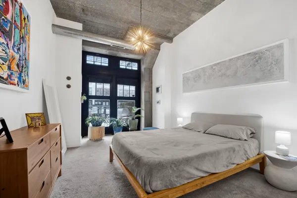 a spacious bedroom with a bed and a large window