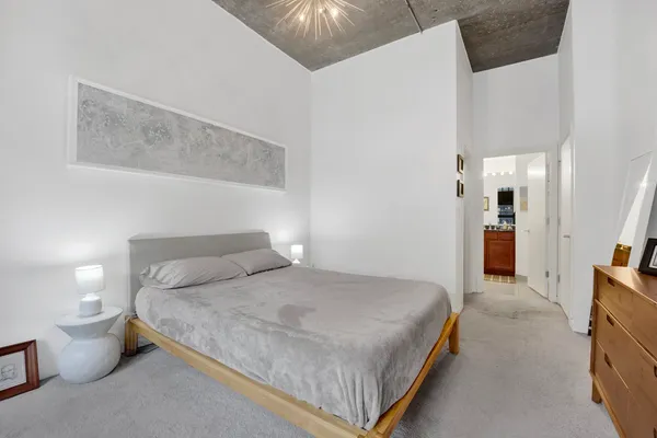 a bedroom with a bed and a chandelier