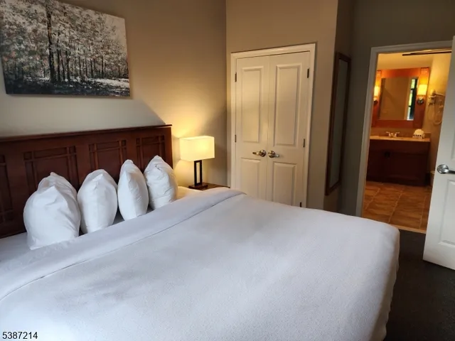 a view of a bedroom with a bed and wooden floor
