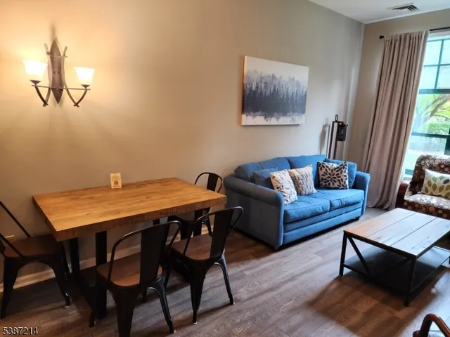 a living room with furniture a wooden floor and a window