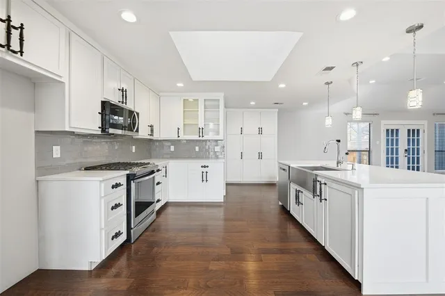 a kitchen with stainless steel appliances kitchen island granite countertop a stove a sink and a refrigerator
