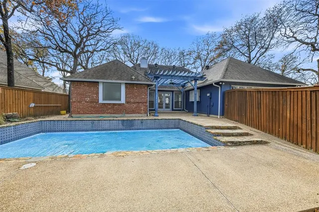 a view of a house with a yard and large tree
