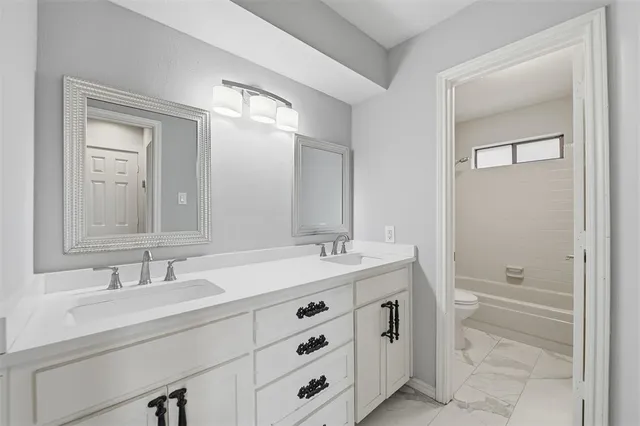 a bathroom with a double vanity sink and mirror with shower