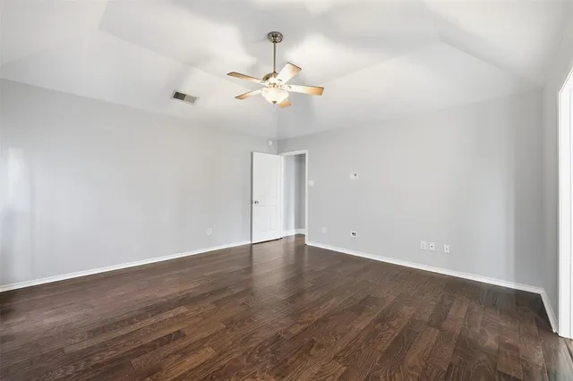 a view of an empty room with wooden floor