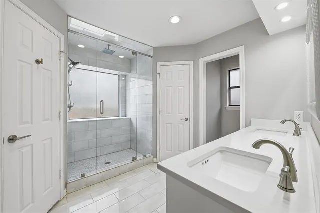 a bathroom with a shower sink and mirror