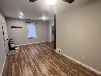 a view of a room with wooden floor and a window