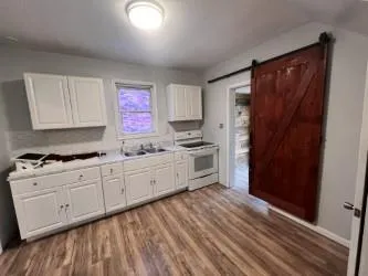 a kitchen with granite countertop white cabinets and stainless steel appliances
