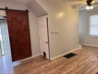an empty room with wooden floor and windows