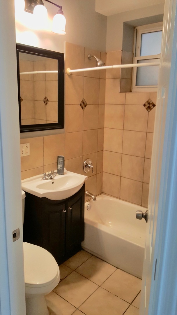 5708 South Aberdeen Street Chicago, IL 60621 - Photo 12 of 25 a bathroom with a sink and a mirror