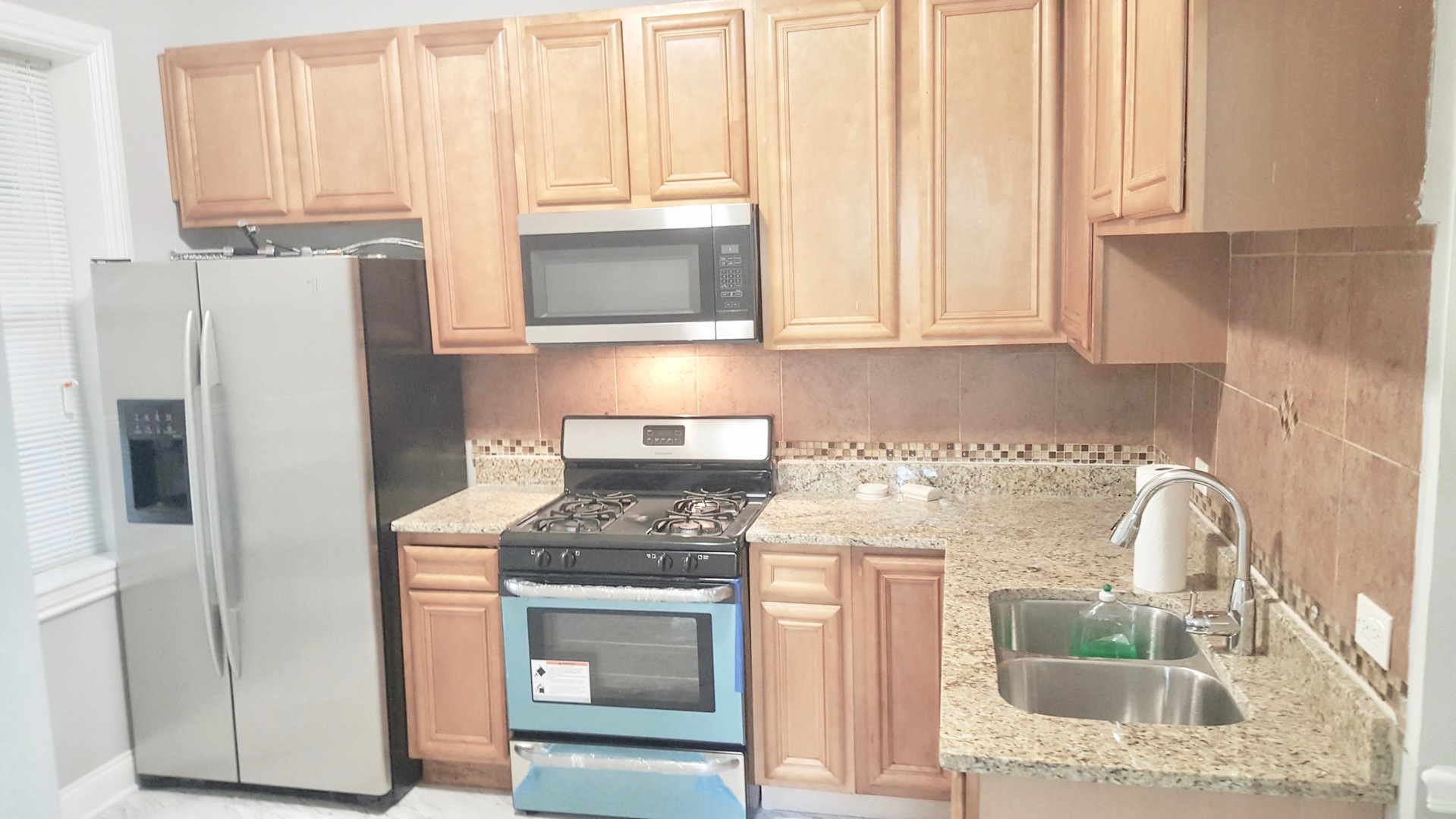 5708 South Aberdeen Street Chicago, IL 60621 - Photo 7 of 25 a kitchen with stainless steel appliances granite countertop a stove a refrigerator and a sink