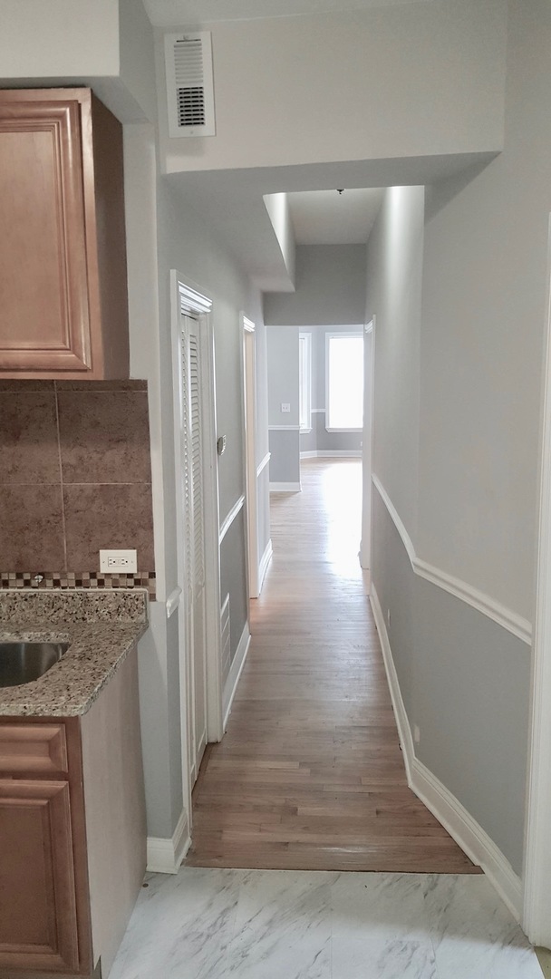 5708 South Aberdeen Street Chicago, IL 60621 - Photo 9 of 25 a view of a hallway with wooden floor and staircase