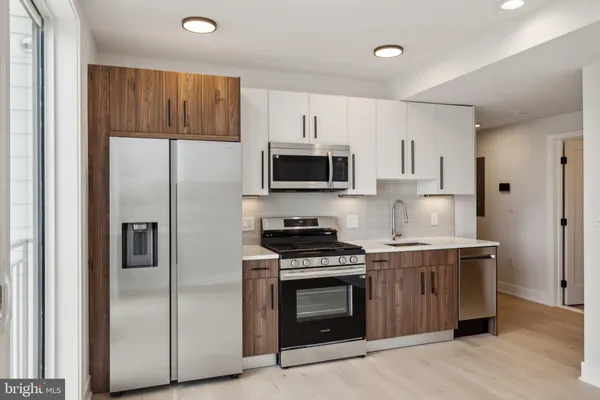 a kitchen with stainless steel appliances granite countertop a stove a refrigerator and a microwave