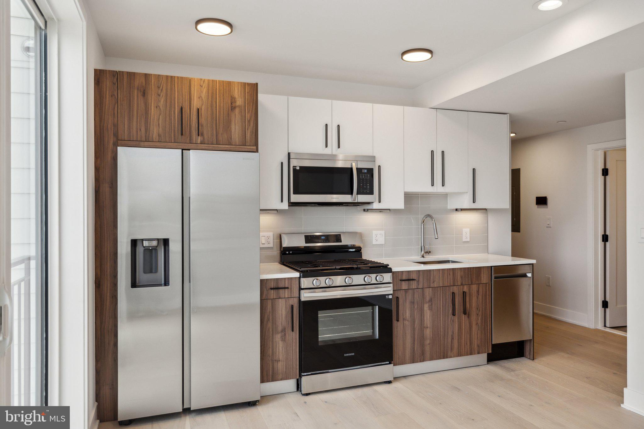845 19th Street Northeast, Unit PH13 Washington, DC 20002 - Photo 1 of 14 a kitchen with stainless steel appliances granite countertop a stove a refrigerator and a microwave