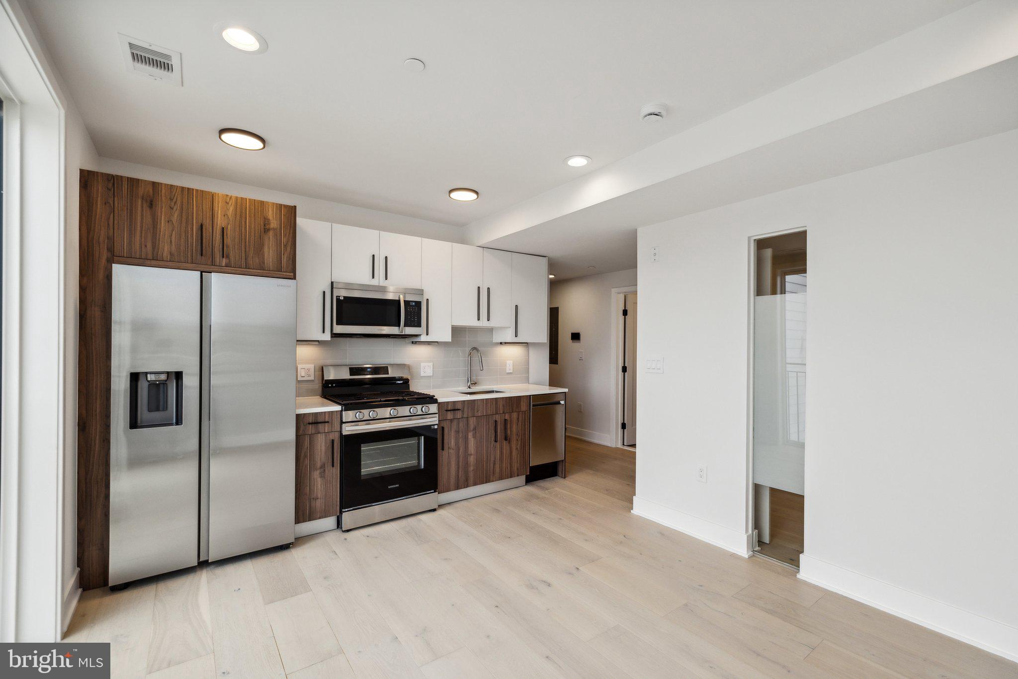 845 19th Street Northeast, Unit PH13 Washington, DC 20002 - Photo 2 of 14 a kitchen with stainless steel appliances granite countertop a refrigerator a stove top oven a sink and dishwasher