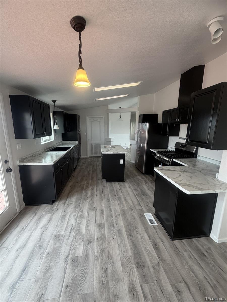 5511 Ridgetop Court Alamosa, CO 81101 - Photo 3 of 10 a kitchen with stainless steel appliances a stove a sink and a refrigerator
