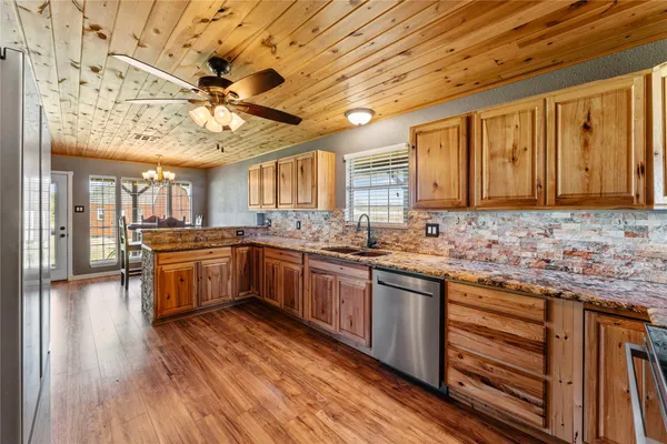 a kitchen with stainless steel appliances granite countertop a stove cabinets and wooden floor