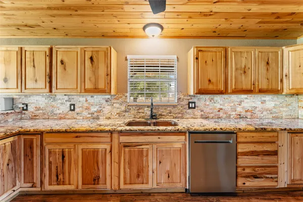 a kitchen with granite countertop a sink and cabinets