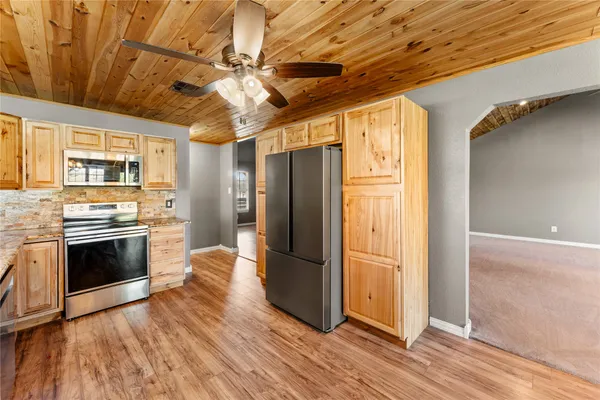 a kitchen with stainless steel appliances granite countertop a refrigerator and a stove top oven