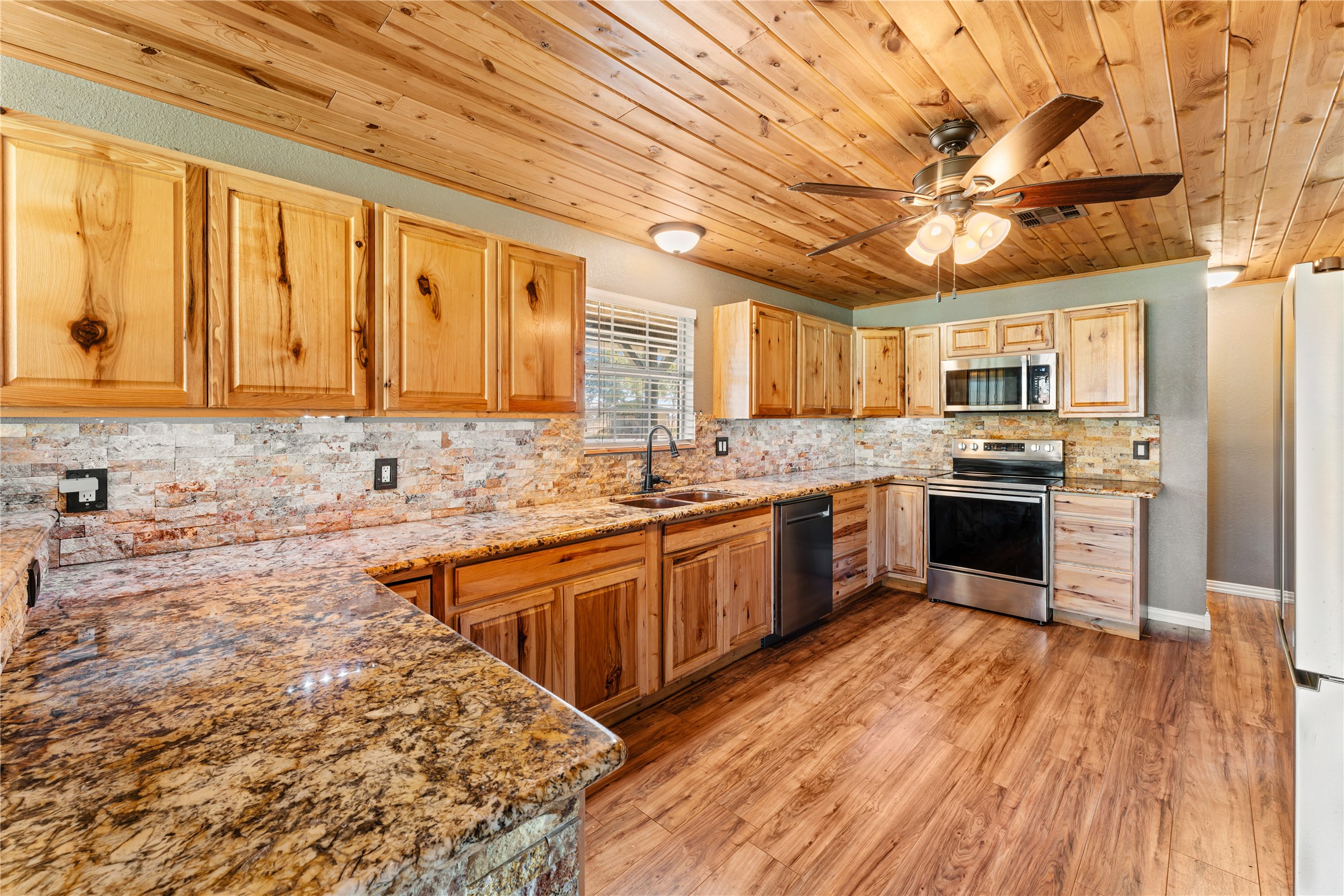 36610 Lariat Lane Simonton, TX 77485 - Photo 18 of 43 a kitchen with stainless steel appliances granite countertop a sink cabinets wooden floor and a counter top space