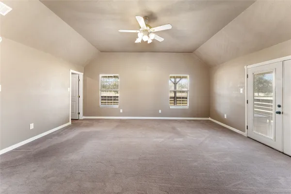 an empty room with closet and a ceiling fan